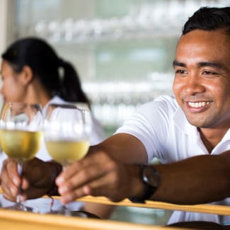 Happy bartender serving a drink