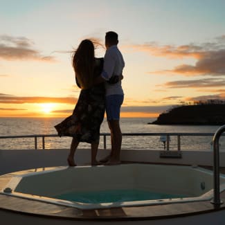 A couple on a deck looking at sunset